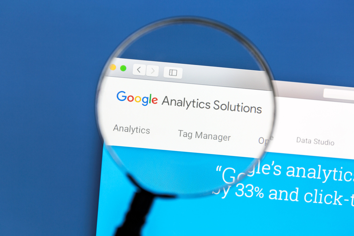 Google Analytics screen being inspected by a magnifying glass for a new website launch.